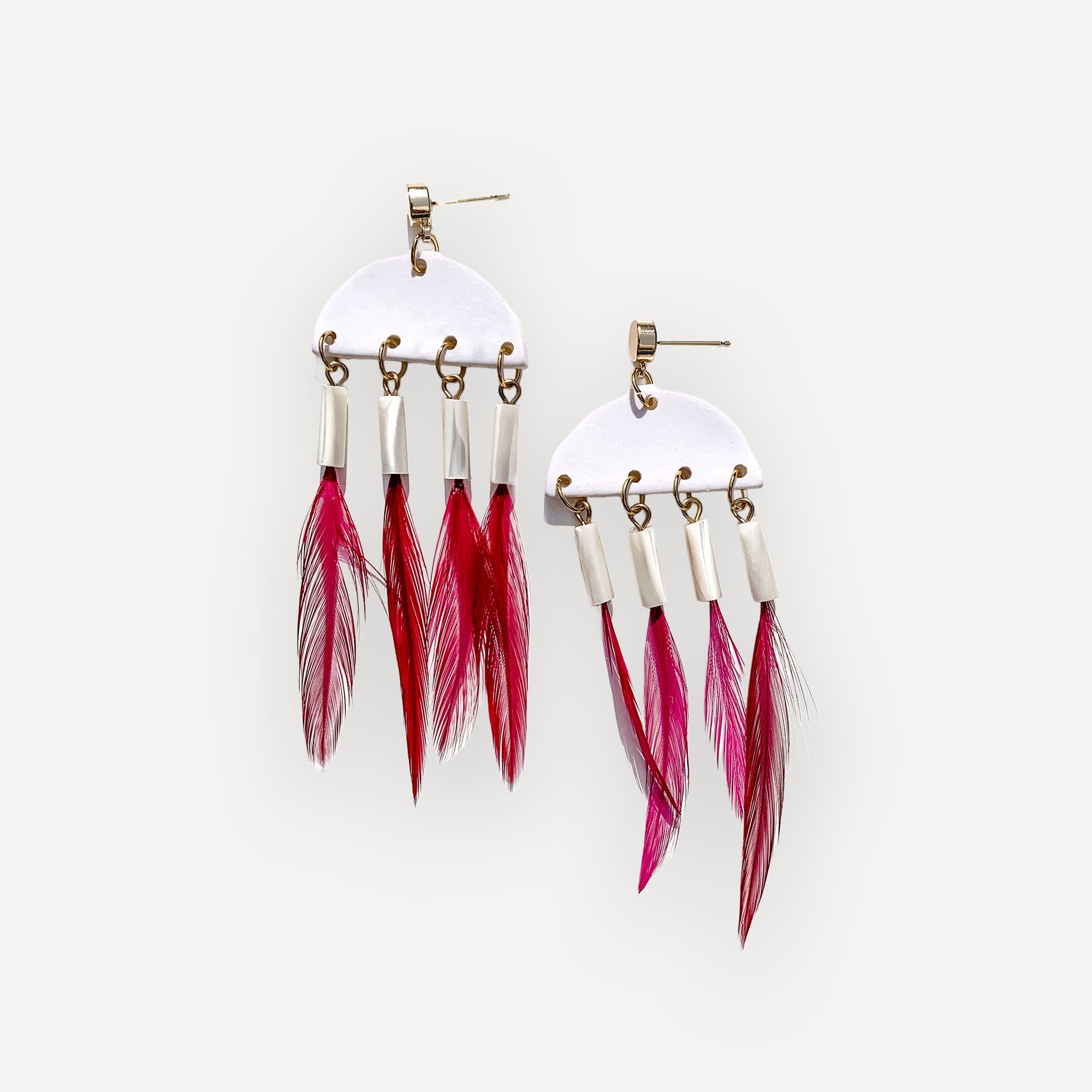 Clay and pink feather earrings on white background