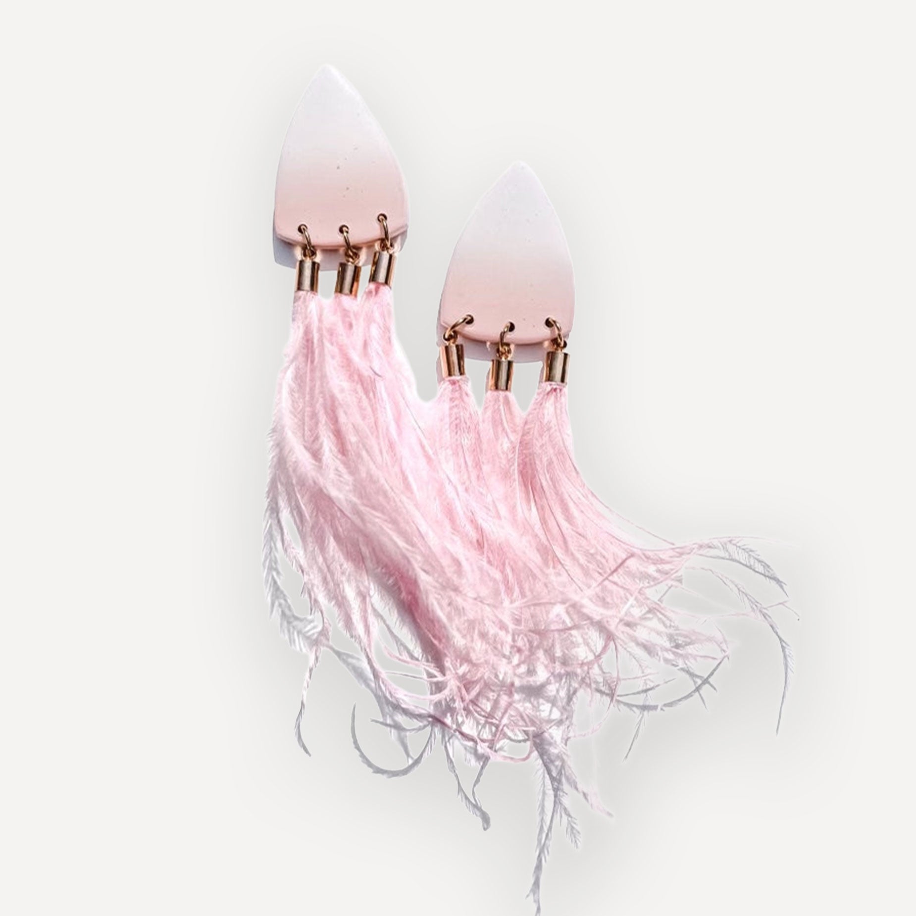 Pink statement earrings on a white background