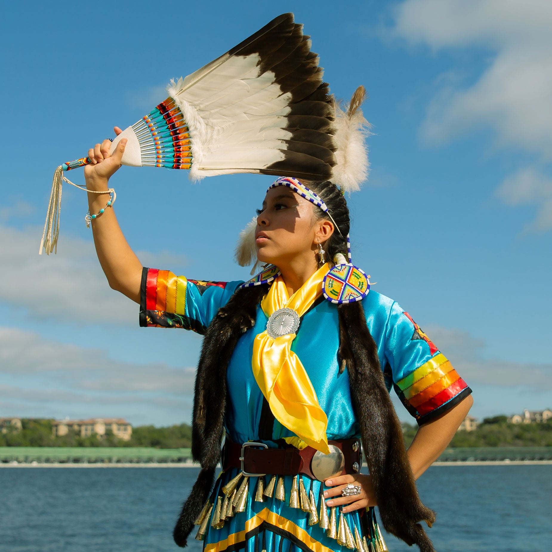 Navajo lady in regalia ribbon dress with eagle feather fan and large concho belt