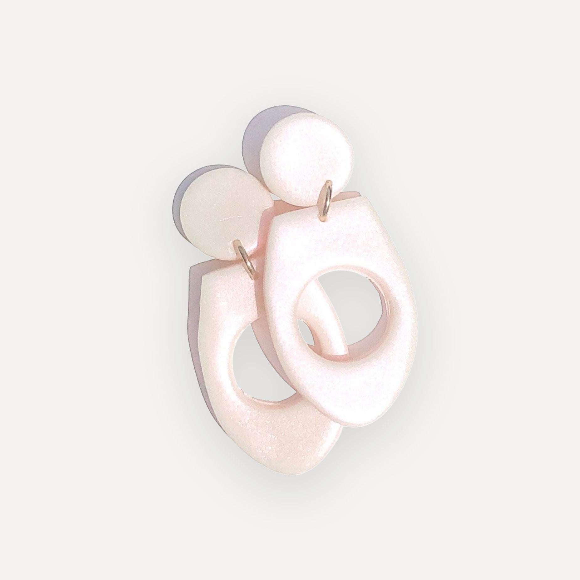 Pink abstract earrings on a light gray background