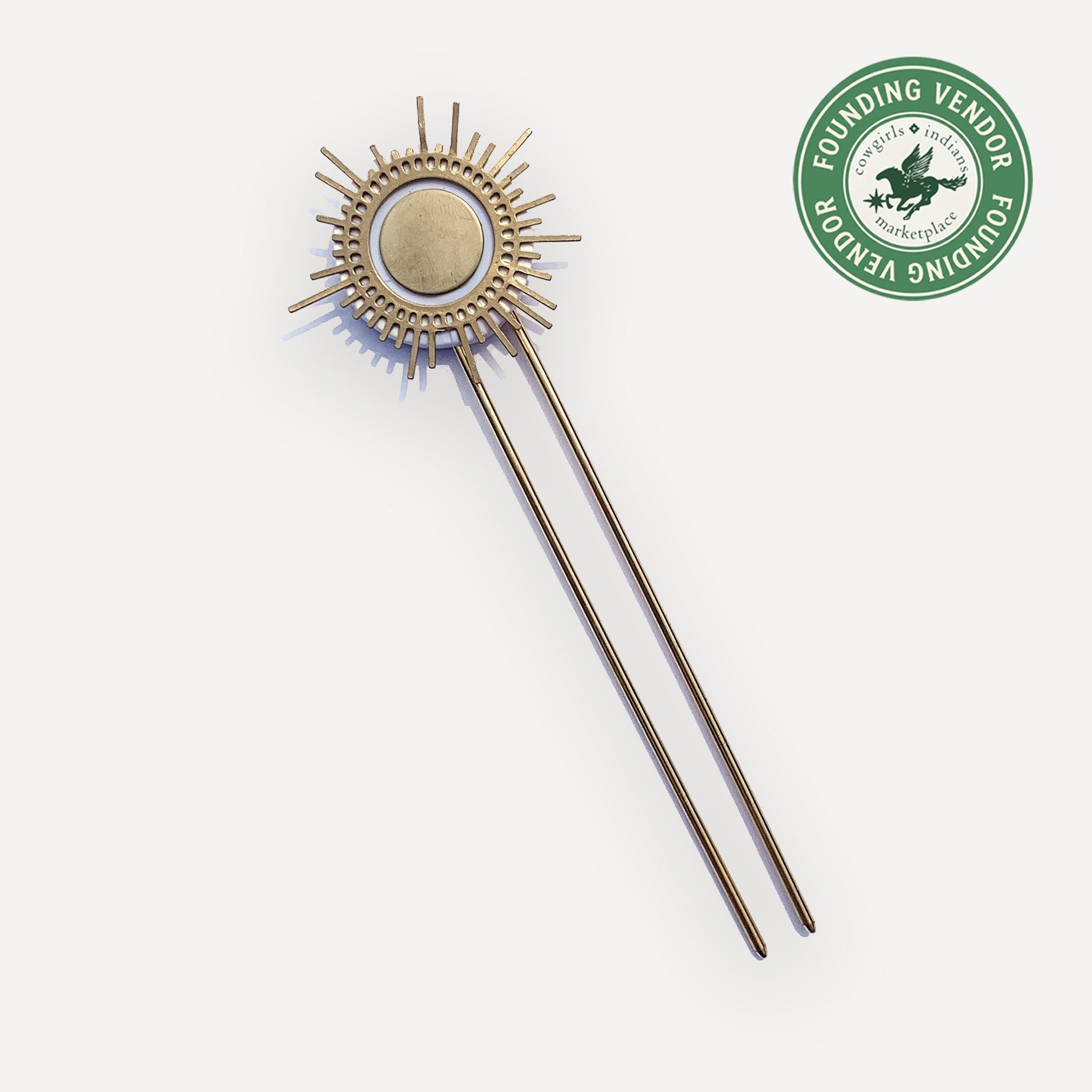 Decorative sun-shaped object with a circular center on a white background, featuring a 'Founding Vendor' logo.