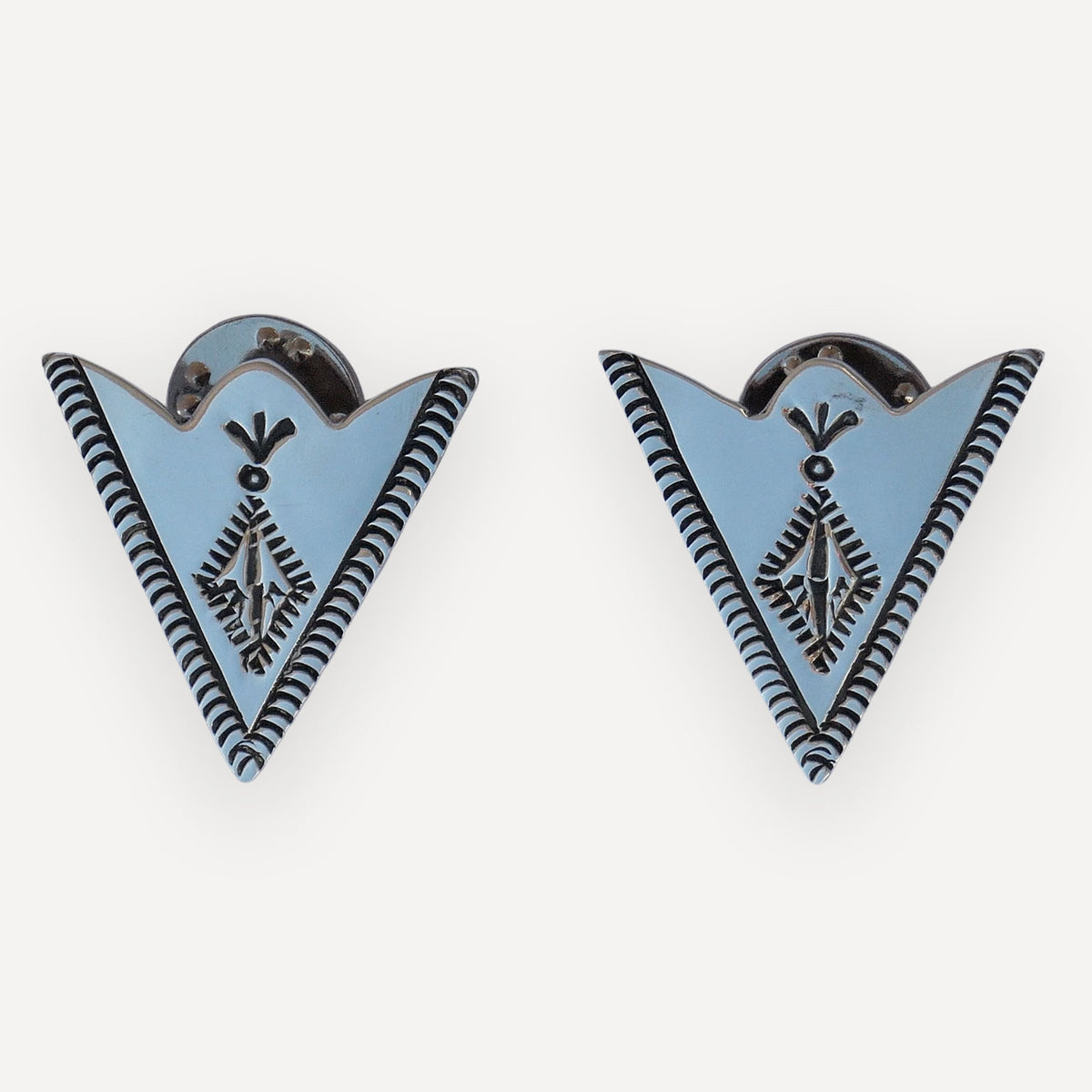 Pair of sterling silver collar tips with a stamped indian paintbrush bloom and rope borders on a white background