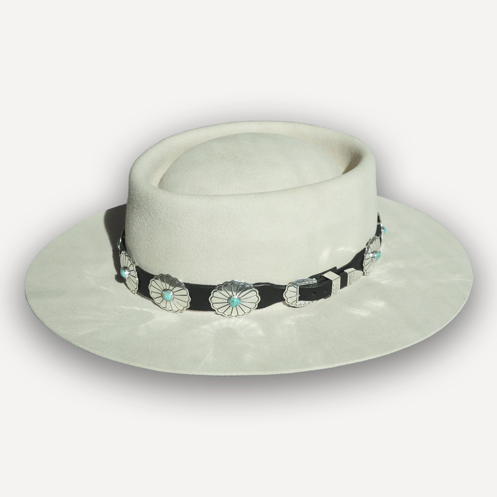 White cowgirl hat with navajo band on a light gray background