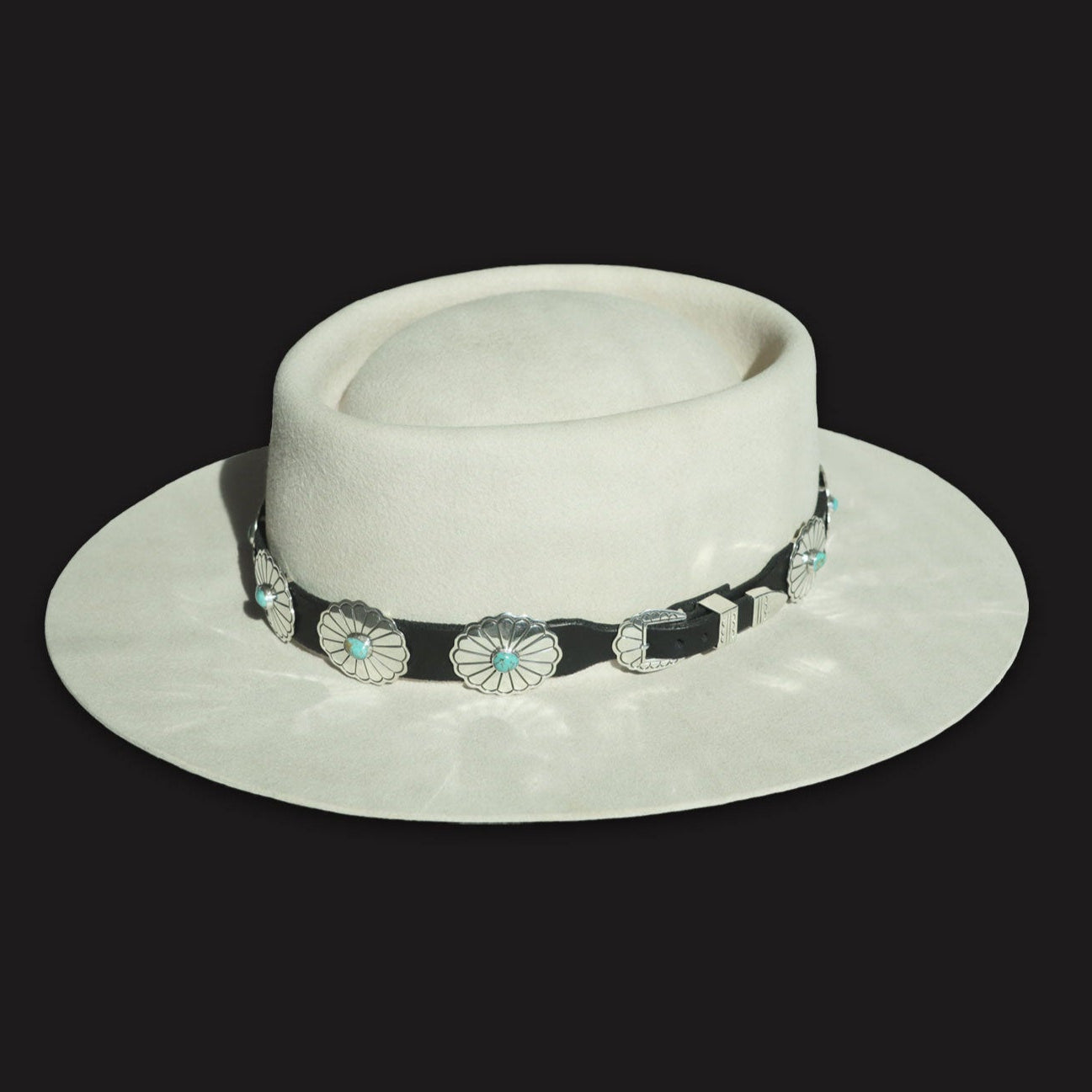 Rough Rider leather concho hatband showing the adjustable silver buckle closure, on a light felt hat.