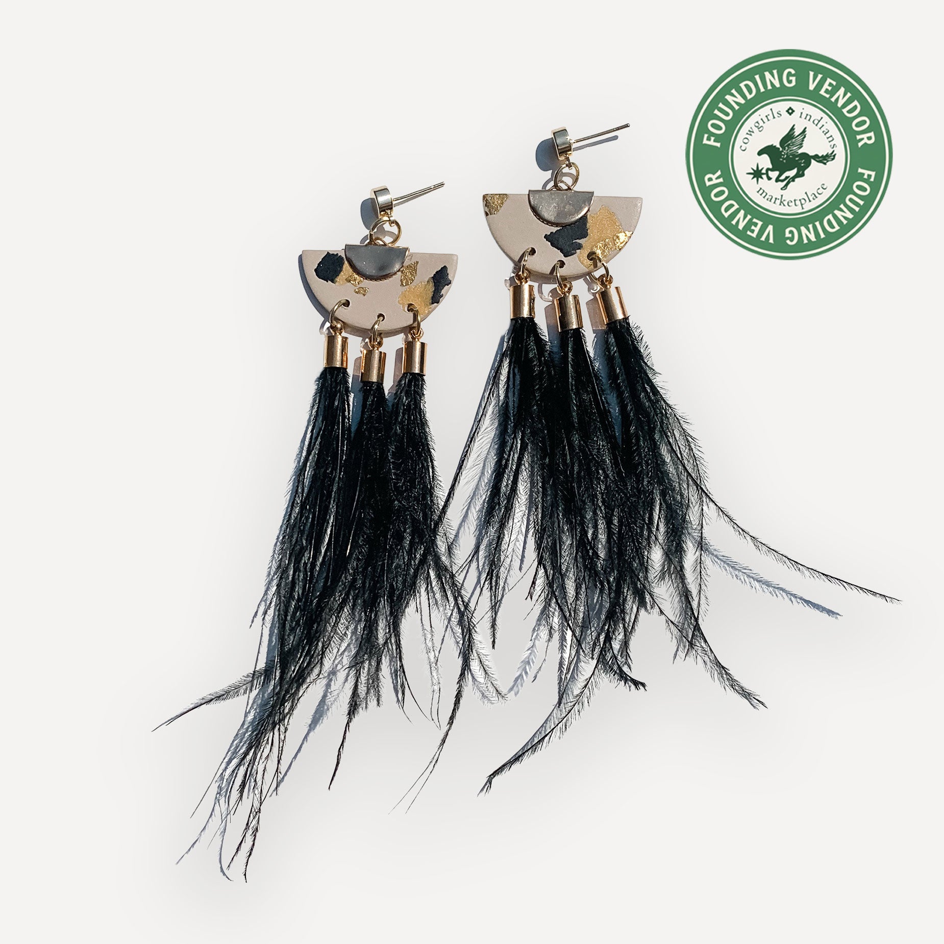 Black ostrich feather earrings with gold accents on a white background, featuring a Founding Vendor badge.