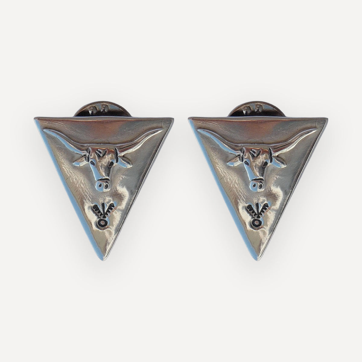 Pair of triangular sterling silver collar tips with a sculpted texas longhorn steer and hand-stamped navajo details on a white background