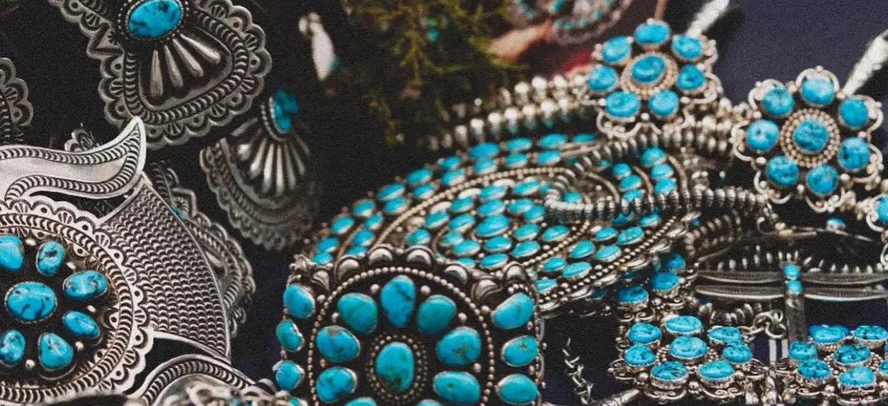 Silver and turquoise navajo jewelry displayed on a table. Up close details of turquoise stones and handstamped accents.