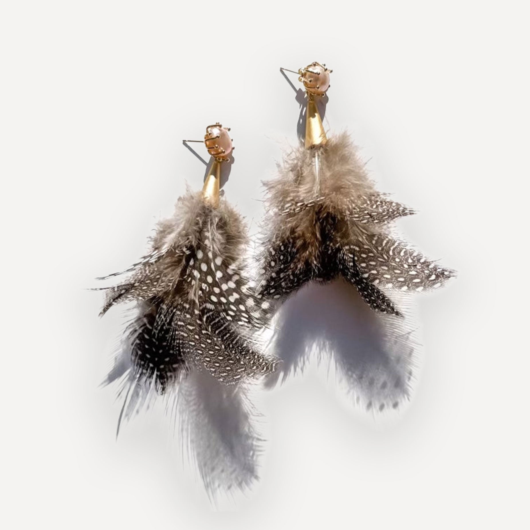 Pearl Duster Feather earrings with gold hooks on a white background