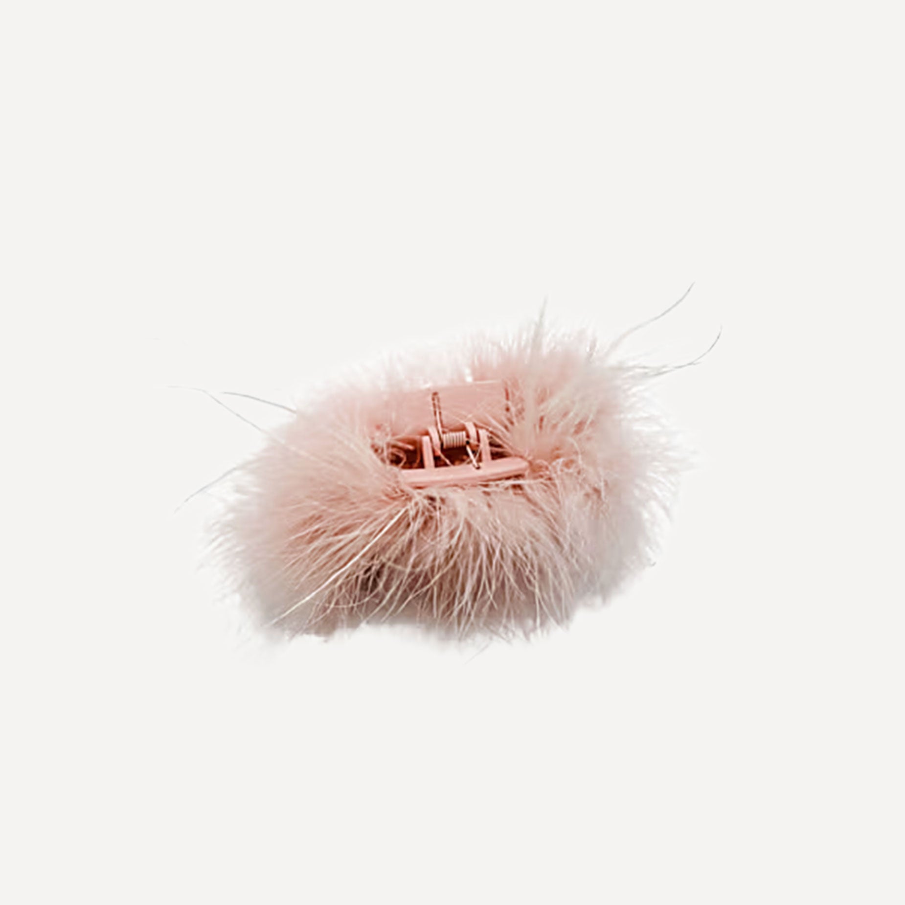 Pink fluffy hair clip on a white background