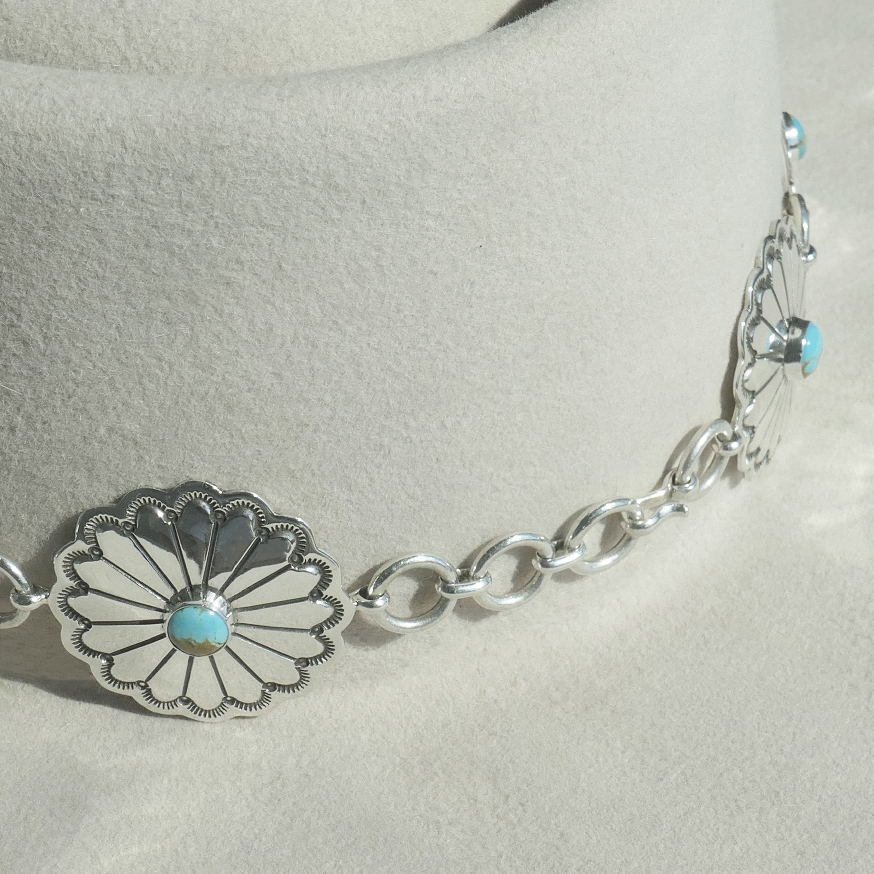 Close-up of Nizhoni Navajo hatband showing sterling silver chain links connecting the turquoise conchos.