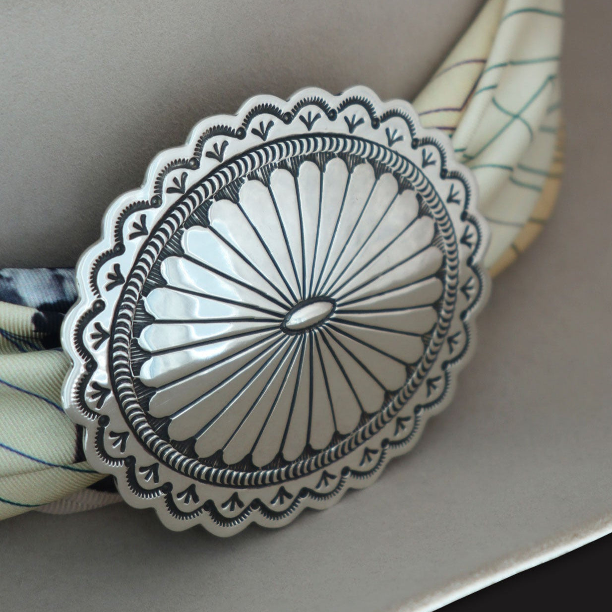 Oversized 4 Corners Diné concho scarf slide in sterling silver: Close-up of Lee Charley's traditional Navajo stampwork and mirror-polish finish.
