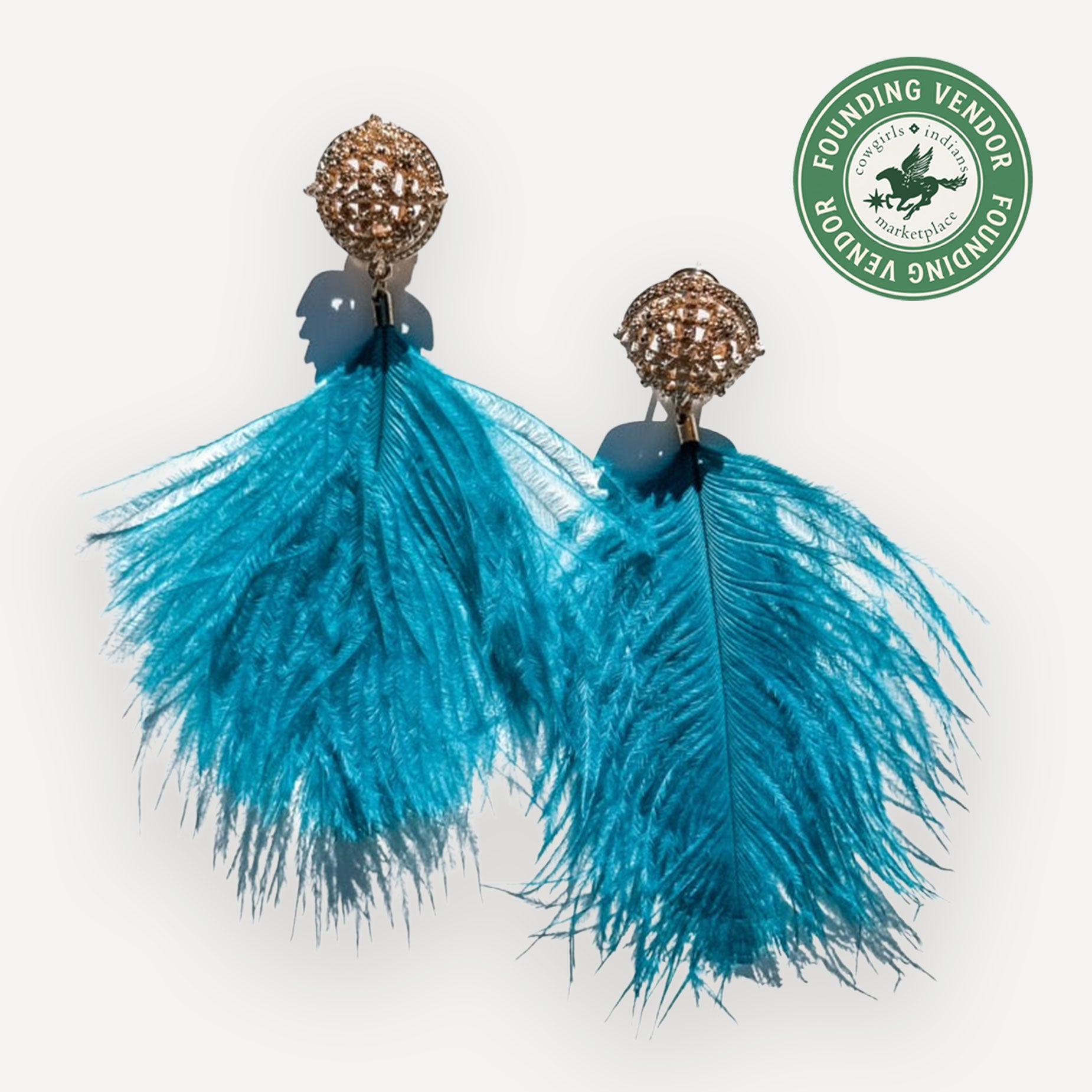 Turquoise feather earrings with gold spherical tops on a white background, featuring a Founding Vendor logo.