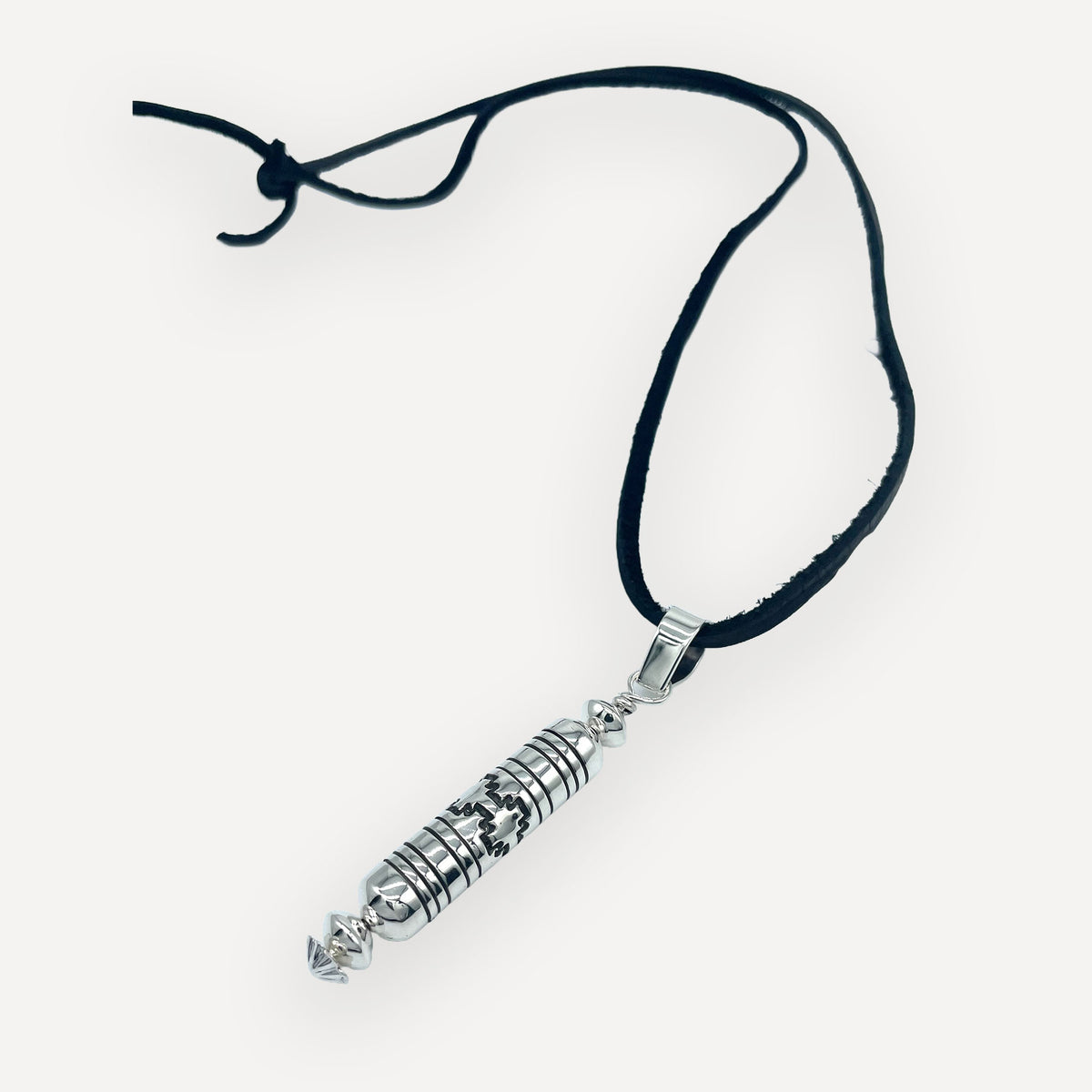 Angled view of a sterling silver barrel bead mesa pendant showing oxidized stepped mesa stampwork and fluted bail