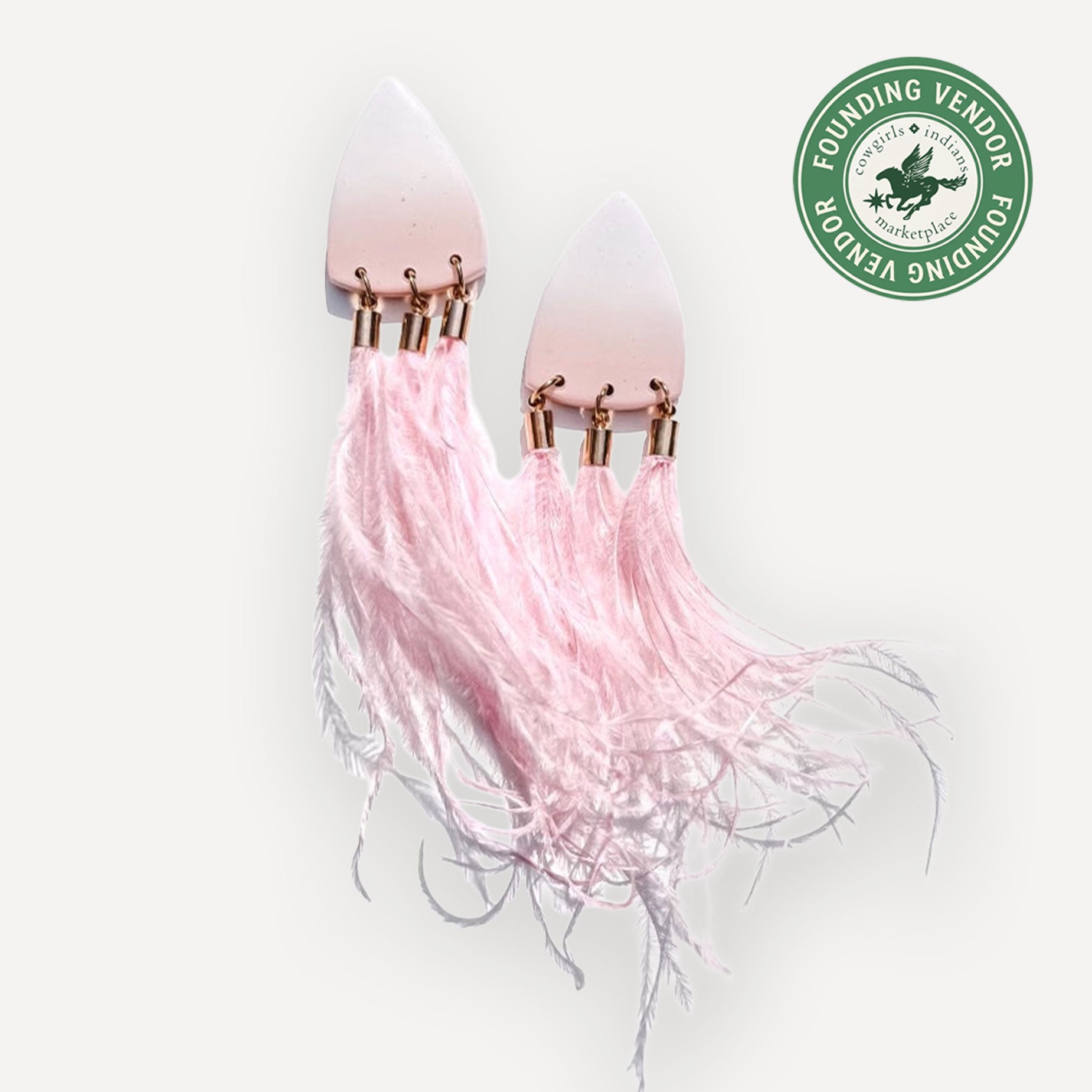Pink clay and ostrich feather earrings on a white background with a green logo in the corner.