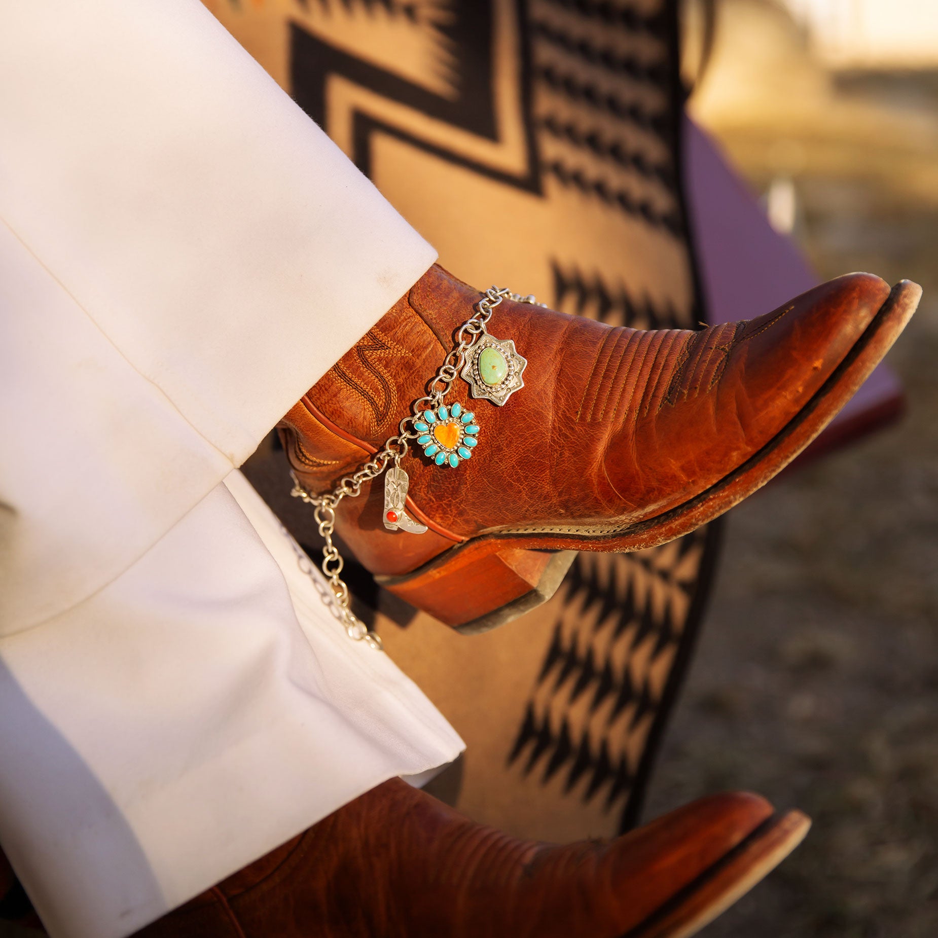 Brown Cowboy Boots with Boot Jewelry and Charms on a pendleton blanket 