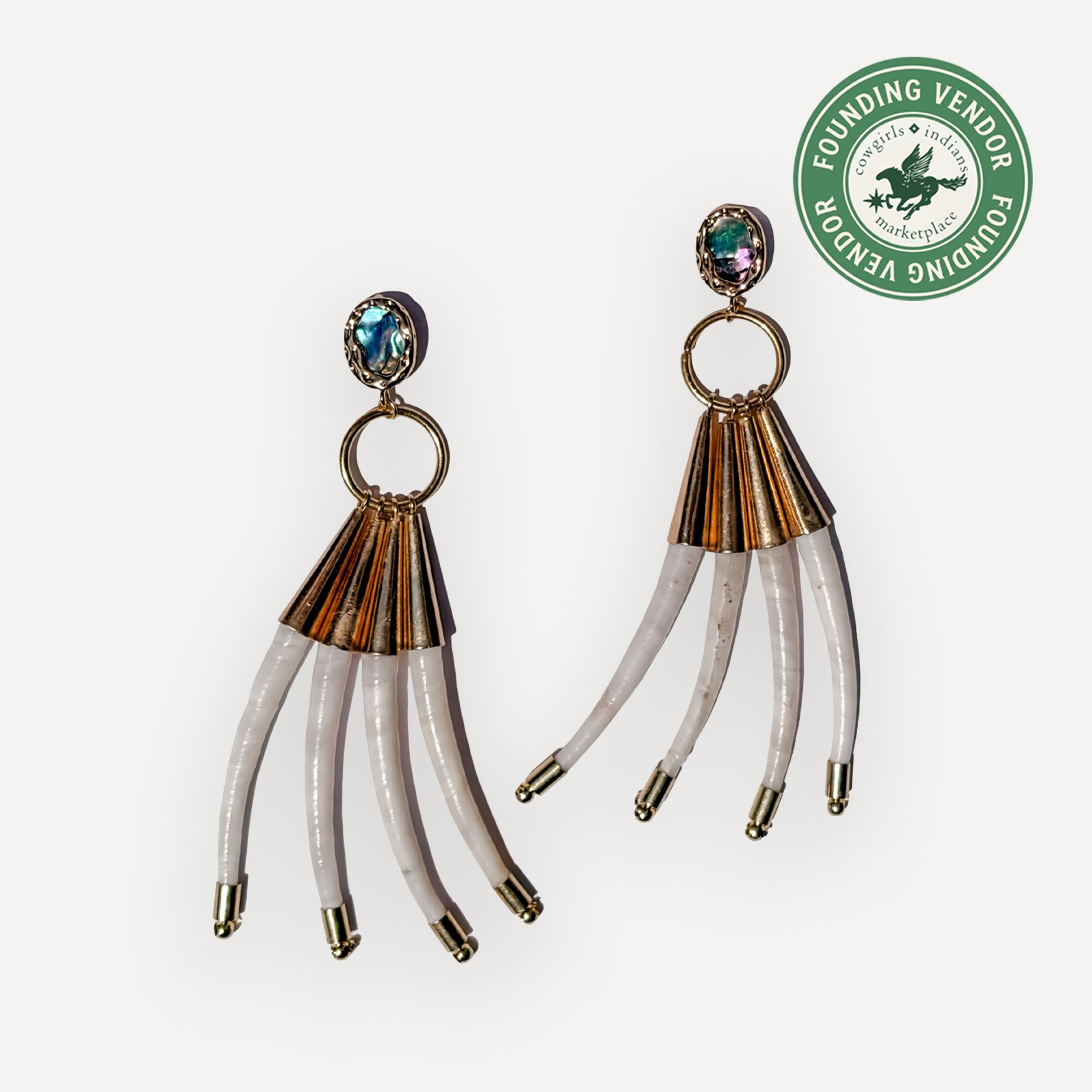 Pair of gold and dentalium earrings on a white background