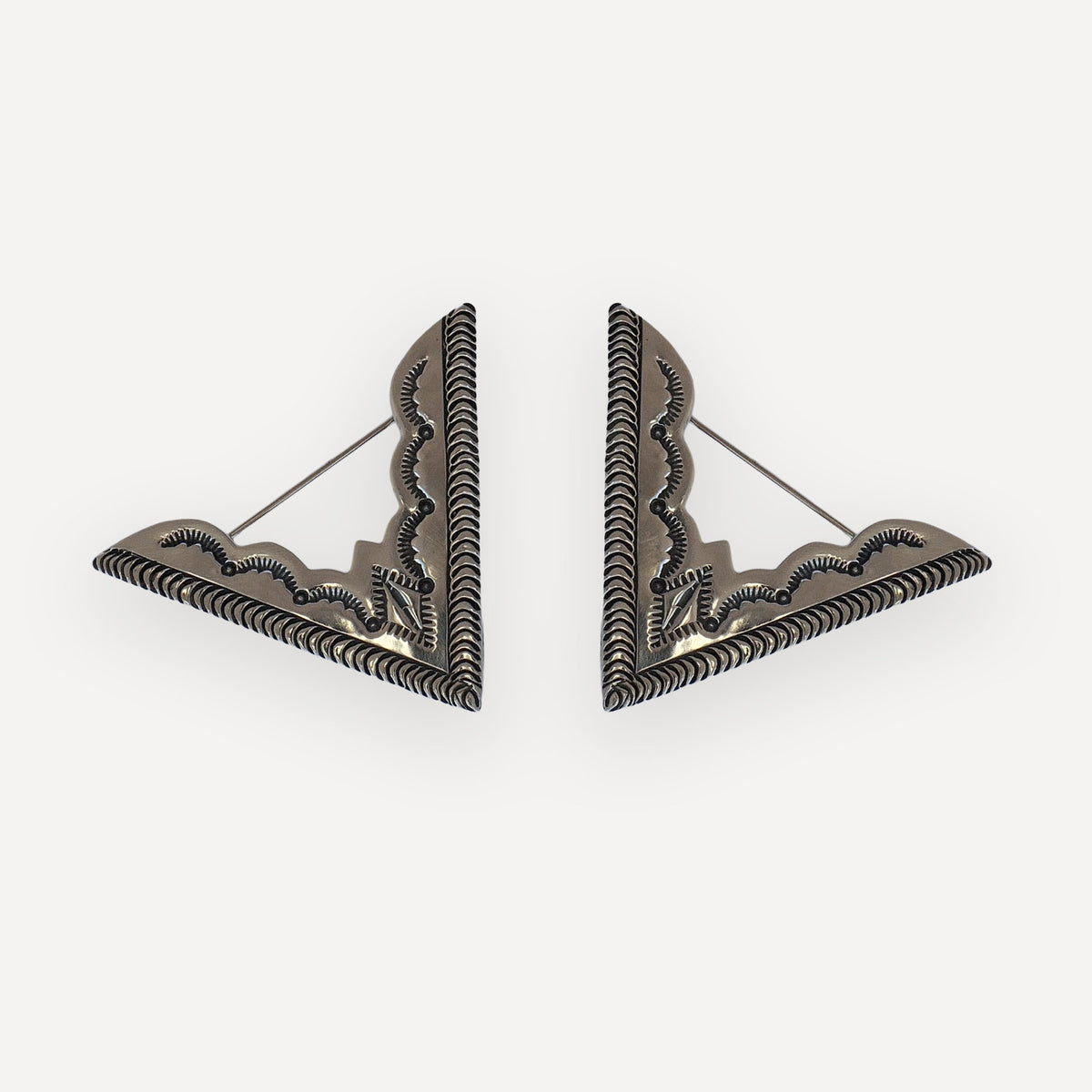 Pair of oversized open-frame sterling silver collar tips with deep rope-stamped borders and navajo stampwork on a white background
