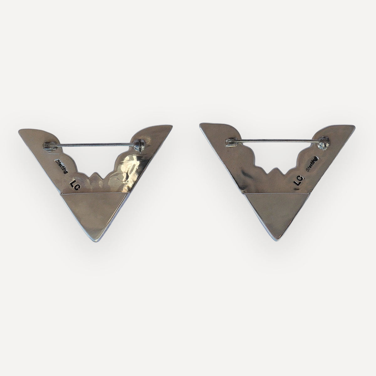Back of two oversized sterling silver collar tips with Sterling and LC hallmarks and bar pin closures