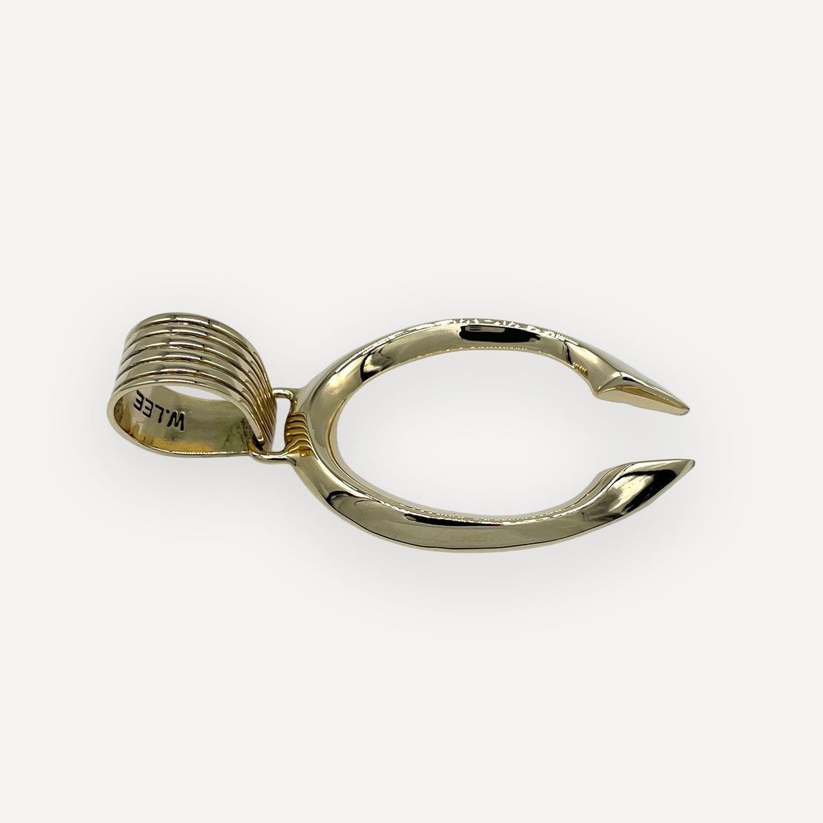 Angled view of a gold gothic naja pendant with tapered spire points and 18K stamp inside the bail