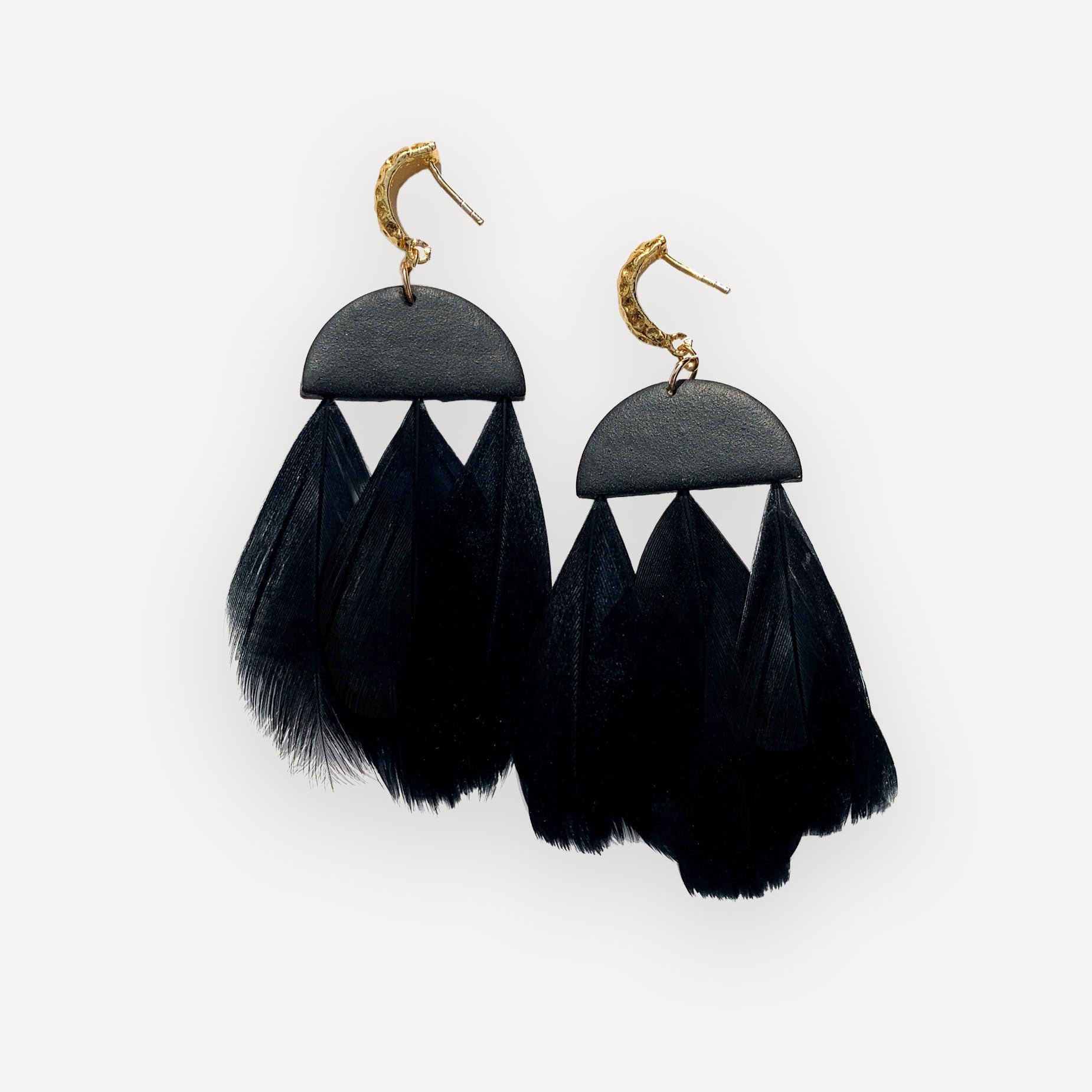 clay and feather black dangle earrings on white background