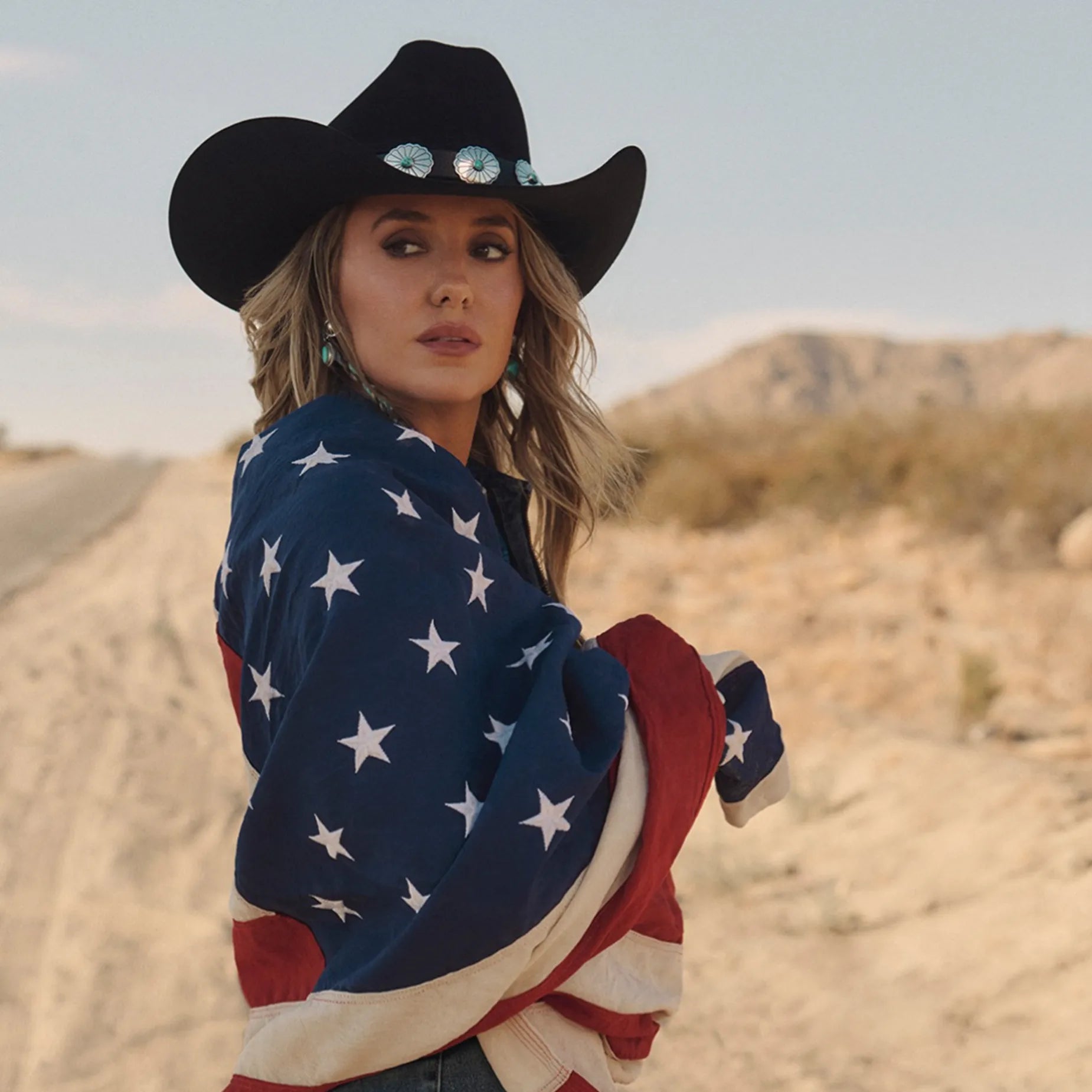 Lainey Wilson wearing a Cowgirls & Indians Navajo hat band wrapped in an American Flag in Joshua Tree, California