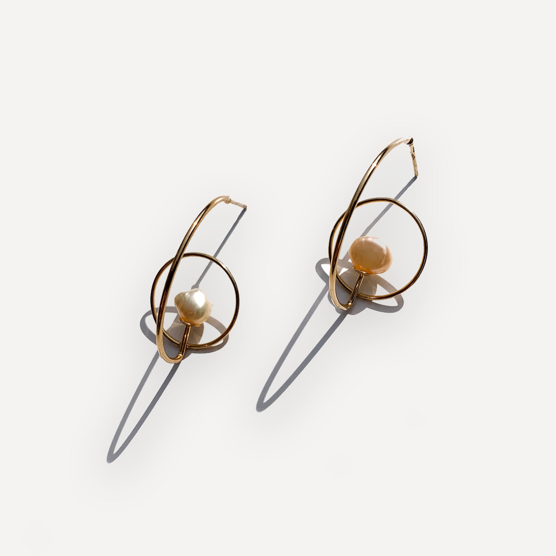 Gold earrings with pearls on a white background