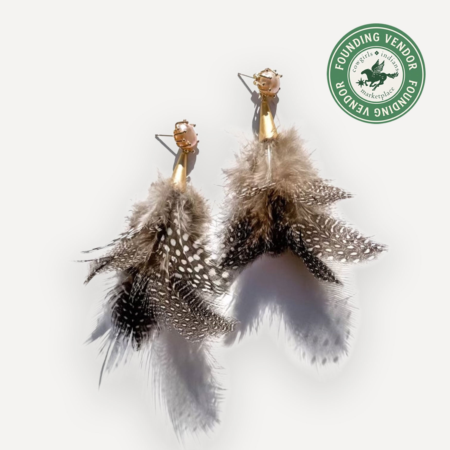 Feather earrings with gold hooks on a white background, featuring a Founding Vendor logo.