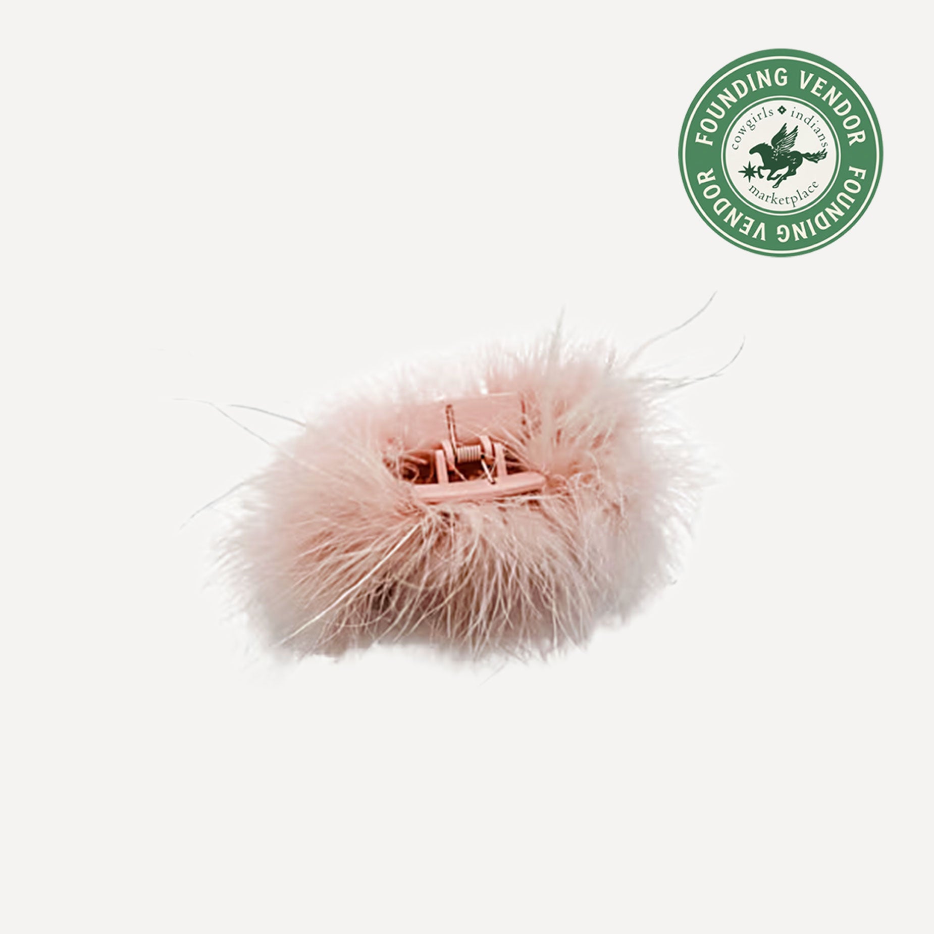 Pink feathered hair clip on a white background with a green logo in the corner.