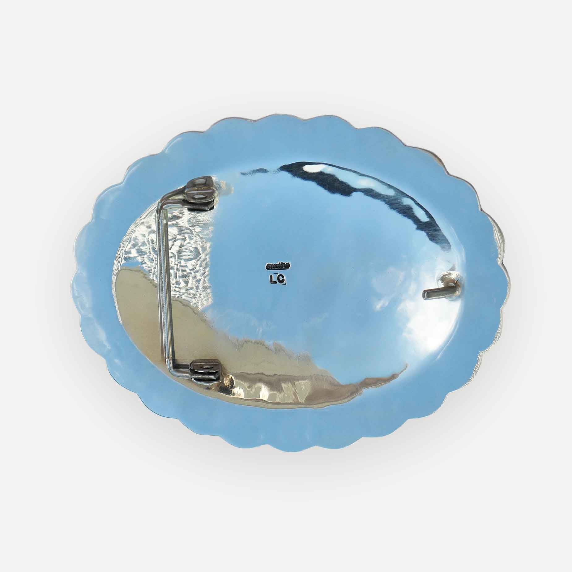 The back view of a scalloped oval western belt buckle on a white background